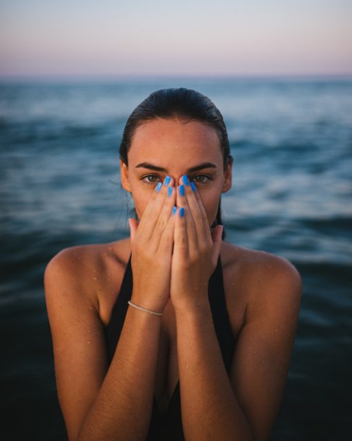 Woman on the beach covering her face