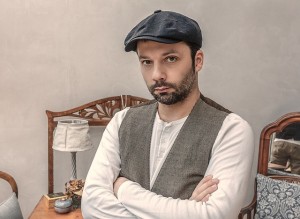 Man with vest and beret, looking grumpy, complacent, or dissatisfied